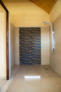 a bathroom with a shower with a brick wall at Mahafaly Hotel & Resort in Antsirabe