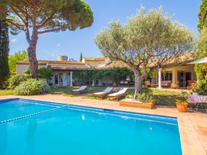 a pool in front of a house with trees at Villa colette in Sant Antoni de Calonge