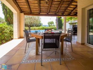 a patio with a wooden table and chairs at Villa colette in Sant Antoni de Calonge