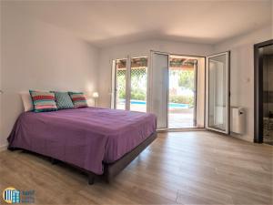a bedroom with a purple bed and a sliding glass door at Villa colette in Sant Antoni de Calonge