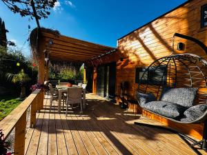 une terrasse en bois avec une table et des chaises. dans l'établissement Yucca tiny house, à Orta
