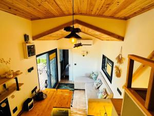 a living room with a couch and a wooden ceiling at Yucca tiny house in Orta