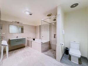 a bathroom with a shower and a toilet and a sink at Elegant Bayside Retreat with Stunning Bay Views in Melbourne