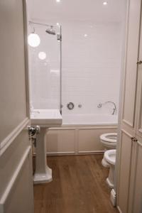 uma casa de banho com um chuveiro, um lavatório e um WC. em Sapphire Sanctuary em Londres