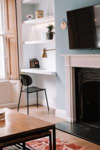 - un salon avec une chaise et une cheminée dans l'établissement Sapphire Sanctuary, à Londres