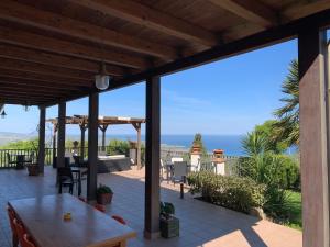 eine Terrasse mit einem Tisch und Meerblick in der Unterkunft Villa Zufrò in Vibo Valentia