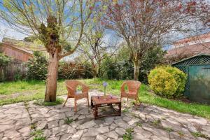 duas cadeiras e uma mesa num quintal em Echappee familiale dans cette grande maison em Lanton