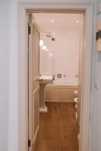 La salle de bains est pourvue d'un lavabo et d'une baignoire. dans l'établissement Sapphire Sanctuary, à Londres