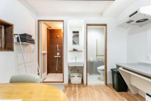 a bathroom with a toilet and a sink and a table at Hostel Ayame in Kyoto