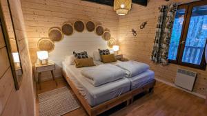 a bedroom with a bed with a wooden wall at Chalets de vacances Castelwood in Biron