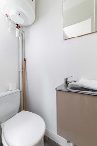 uma casa de banho com um WC branco e um lavatório. em Studio cosy metro saint Paul - Paris 3 - 2P em Paris