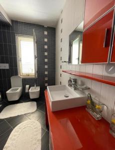 ALBJONA GUESTHOUSE TIRANA في تيرانا: حمام مع حوض ومرحاض