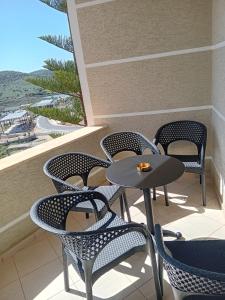 stół i krzesła na balkonie z widokiem na plażę w obiekcie Villa Sarti w mieście Ksamil