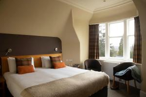 a bedroom with a large bed and a window at The Murray Park Hotel in Crieff