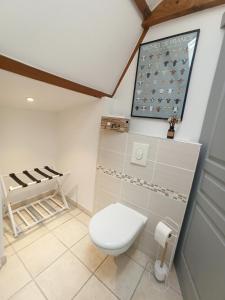 a bathroom with a toilet in a room at Le Cottage des Falaises in Gonneville-sur-Mer