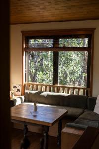 a living room with a couch and a large window at Modern, Cosy Hideaway - Rua Nuka Raglan in Raglan