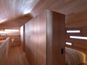 um quarto com paredes de madeira e uma cama num quarto em Mountain Lodge Tamersc em San Vigilio Di Marebbe