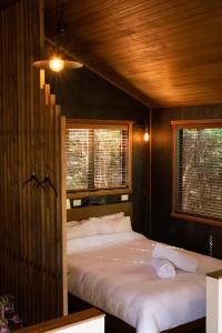 a bedroom with a bed and two windows at Modern, Cosy Hideaway - Rua Nuka Raglan in Raglan