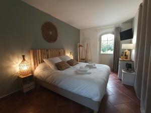 Un dormitorio con una gran cama blanca y una ventana en Le Cottage des Falaises, en Gonneville-sur-Mer