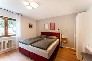 Schlafzimmer mit einem großen Bett mit einem roten Kopfteil in der Unterkunft Juri/35 Schwenningen in Villingen-Schwenningen