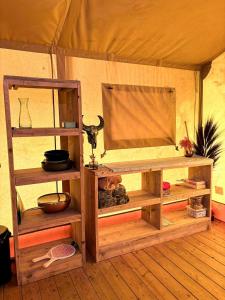 Cette chambre comprend une tente avec des étagères en bois. dans l'établissement Glamping-tent 'Yatra Nirvana' met privé keuken en regendouche, à Grou