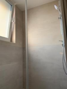 um chuveiro com uma porta de vidro na casa de banho em Aurora Iris em Praga