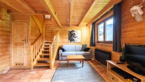 a living room with a staircase in a log cabin at Bois de Champelle -7- Magnifique chalet 8 pers in Morillon
