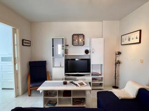 a living room with a tv and a table at Apartamento La Caleta III - Monabri in Mogro