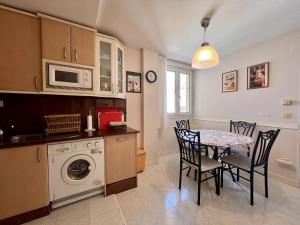 a kitchen with a table and chairs and a microwave at Apartamento La Caleta III - Monabri in Mogro