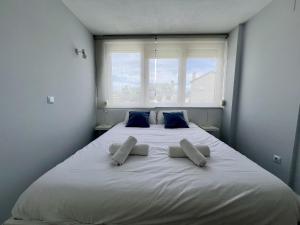 a large white bed with two pillows and a window at Apartamento La Caleta III - Monabri in Mogro +23 photos