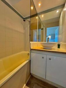 a bathroom with a sink and a tub and a mirror at Rousseau in Théoule-sur-Mer