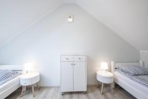 sypialnia z 2 łóżkami i białą szafką w obiekcie Bedroom - domek nr 2 w Łebie