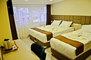 a hotel room with two beds and a window at Yesilirmak Aparts Hotel in Istanbul