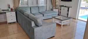 ein Wohnzimmer mit einem blauen Sofa und einem Tisch in der Unterkunft Villa Garmar CTO Approved 4487 in Paralimni