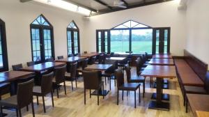a dining room with tables and chairs and windows at Oak Garden 國民旅遊卡特約商店 特斯拉免費充電 in Hualien City