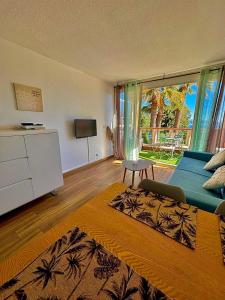 Rousseau في تيول-سور-مير: غرفة معيشة بها أريكة زرقاء وتلفزيون