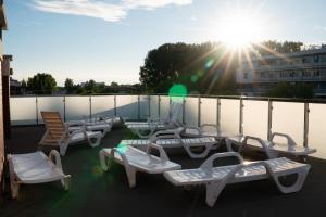 a group of chairs and tables on a balcony at Bliżej Morza Apartament 57 in Kołobrzeg