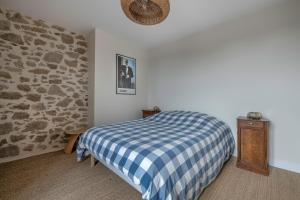 a bedroom with a blue and white checkered bed at Belle maison - 300m des marais - 950m de la plage in Batz-sur-Mer
