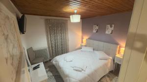 a bedroom with a large white bed in a room at GUESTHOUSE ''ΧΡΥΣΑ'' in Dimitsana