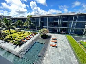 un edificio adibito a ufficio con piscina e sedie a sdraio di 2 Bedroom Beachfront Apartment With Sea Views a Mai Khao Beach