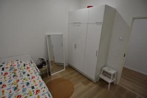 a bedroom with a bed and a large white cabinet at Villa Koivunoksa in Kerava