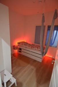 a bedroom with a bed in a room with red lights at Uusi omakotitalo nyt saatavilla! in Kerava