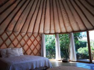 a room with a bed in a yurt with windows at Yourte au coeur du village in Fontvieille
