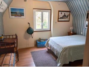 a bedroom with a bed and a window at Maison familiale , Mine d'or à pied in Pénestin