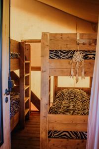 2 Etagenbetten in einem Zimmer mit Zebramuster in der Unterkunft Glamping-tent 'Yatra Nirvana' met privé keuken en regendouche in Grou