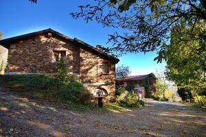 une ancienne maison en pierre assise sur un chemin de terre dans l'établissement B&B LE MIMOSE, à Bricherasio