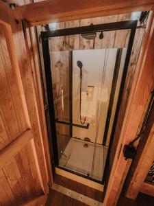 un bagno con doccia e porta in vetro di Glamping-tent 'Yatra Nirvana' met privé keuken en regendouche a Grou