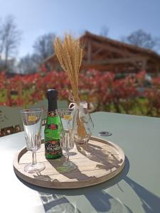 bandeja con una botella de champán y copas en una mesa en Chambre d'hôtes Au Petit Bonheur, en Lorigné