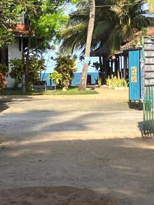a building with a blue door with the ocean in the background at Emerald Bay in Arugam Bay