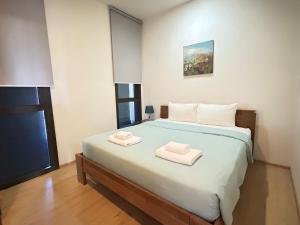 una camera da letto con un letto e due asciugamani di 2 Bedroom Beachfront Apartment With Sea Views a Mai Khao Beach